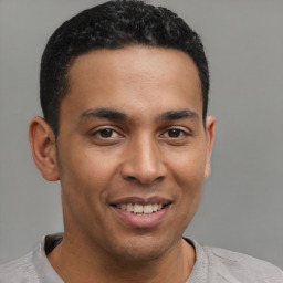 Joyful latino young-adult male with short  brown hair and brown eyes