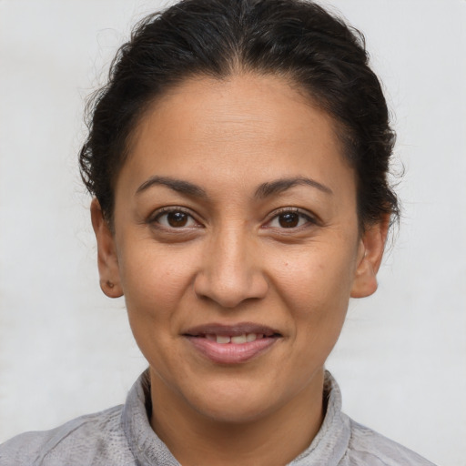 Joyful latino adult female with short  brown hair and brown eyes
