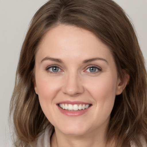 Joyful white young-adult female with medium  brown hair and grey eyes