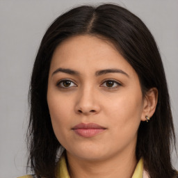 Joyful latino young-adult female with long  brown hair and brown eyes