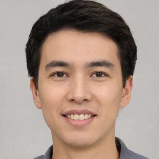 Joyful white young-adult male with short  black hair and brown eyes