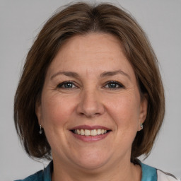 Joyful white adult female with medium  brown hair and grey eyes