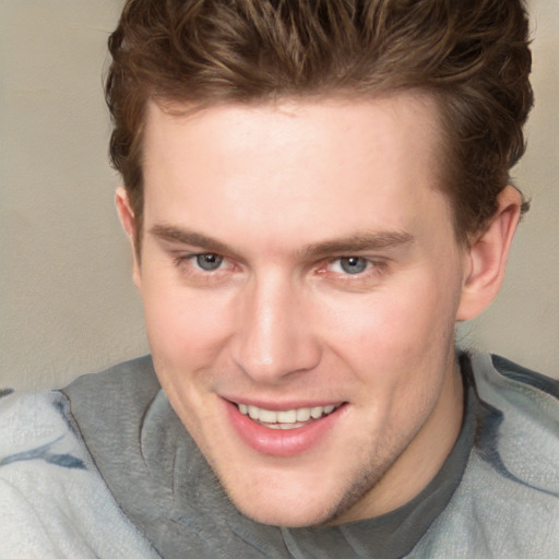 Joyful white young-adult male with short  brown hair and blue eyes