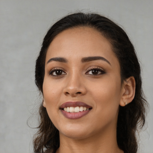 Joyful latino young-adult female with long  black hair and brown eyes