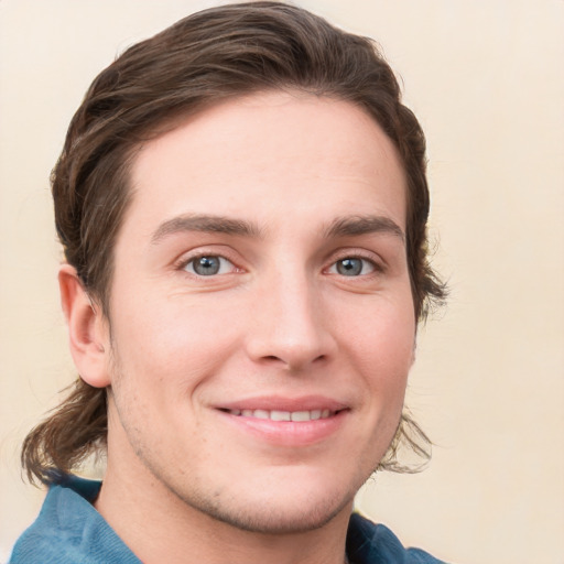 Joyful white young-adult male with medium  brown hair and grey eyes