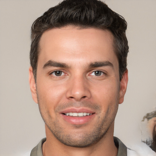 Joyful white young-adult male with short  brown hair and brown eyes