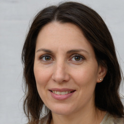 Joyful white adult female with long  brown hair and brown eyes