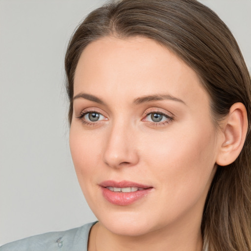 Joyful white young-adult female with long  brown hair and blue eyes