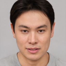 Joyful asian young-adult male with short  brown hair and brown eyes