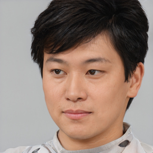 Joyful asian young-adult male with short  brown hair and brown eyes