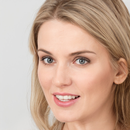 Joyful white young-adult female with long  brown hair and blue eyes