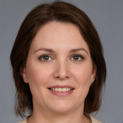 Joyful white young-adult female with medium  brown hair and grey eyes