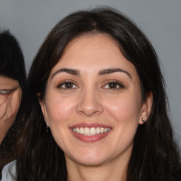 Joyful white young-adult female with long  brown hair and brown eyes