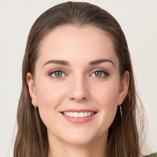 Joyful white young-adult female with long  brown hair and grey eyes