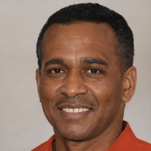 Joyful black adult male with short  black hair and brown eyes