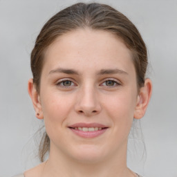 Joyful white young-adult female with medium  brown hair and grey eyes