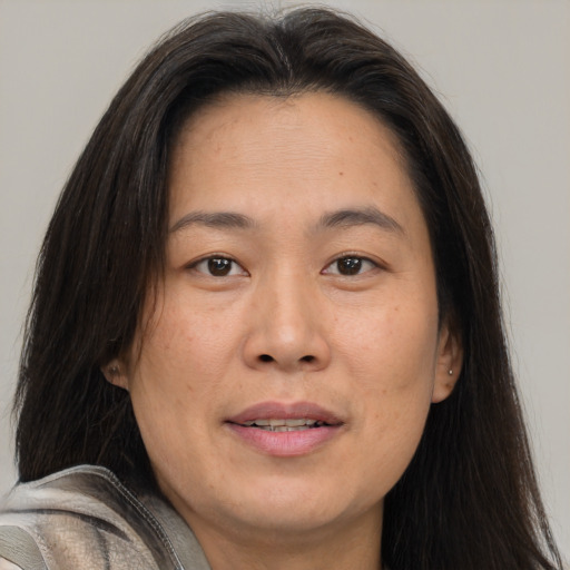 Joyful asian adult female with medium  brown hair and brown eyes
