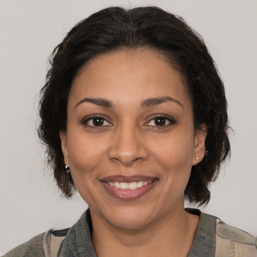Joyful latino adult female with medium  brown hair and brown eyes