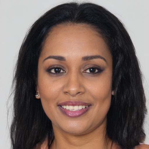 Joyful black young-adult female with long  brown hair and brown eyes