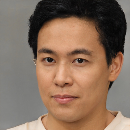 Joyful asian young-adult male with short  brown hair and brown eyes