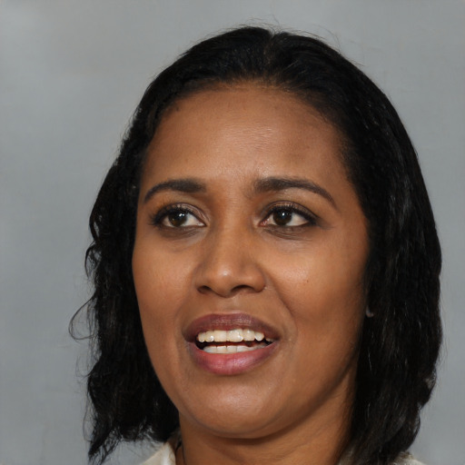 Joyful black young-adult female with long  black hair and brown eyes