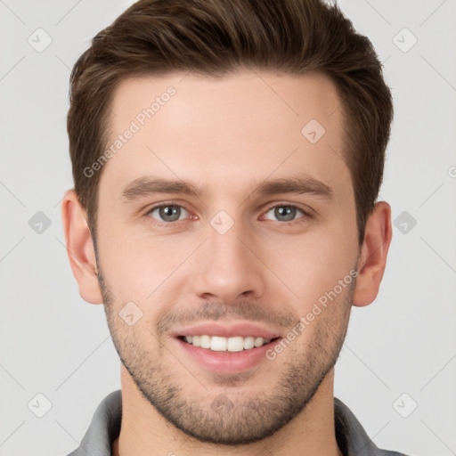 Joyful white young-adult male with short  brown hair and grey eyes