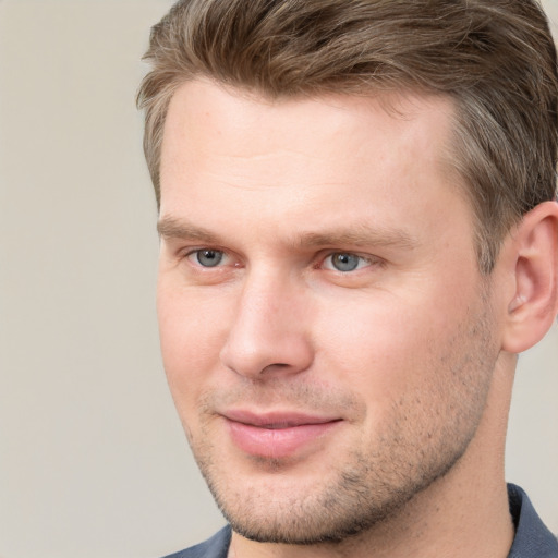 Joyful white young-adult male with short  brown hair and grey eyes