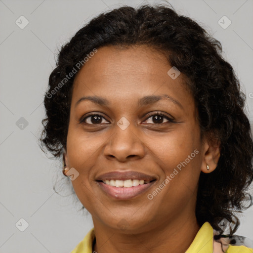 Joyful black adult female with long  brown hair and brown eyes