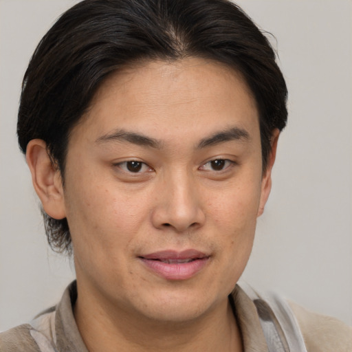 Joyful asian young-adult male with short  brown hair and brown eyes