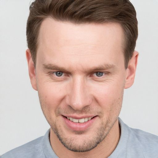 Joyful white adult male with short  brown hair and grey eyes