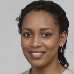 Joyful black young-adult female with long  brown hair and brown eyes