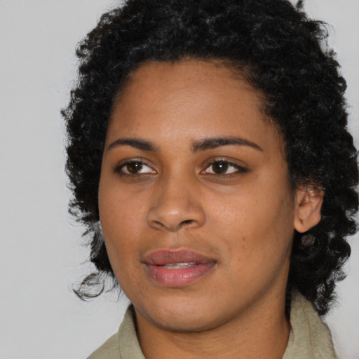 Joyful black young-adult female with medium  brown hair and brown eyes