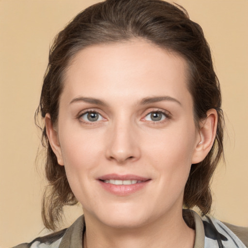 Joyful white young-adult female with medium  brown hair and grey eyes