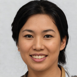 Joyful asian young-adult female with medium  brown hair and brown eyes