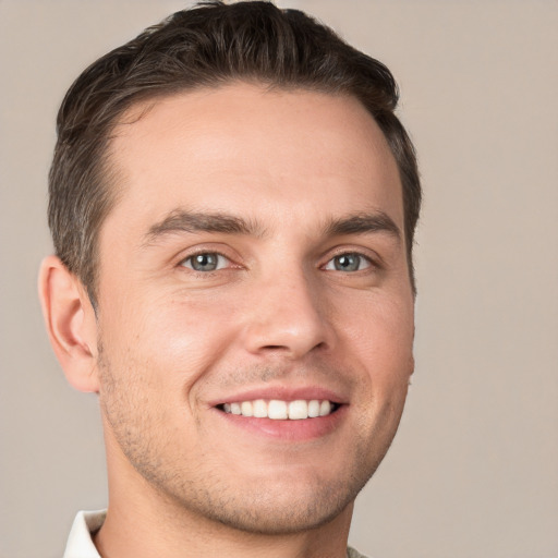 Joyful white young-adult male with short  brown hair and grey eyes