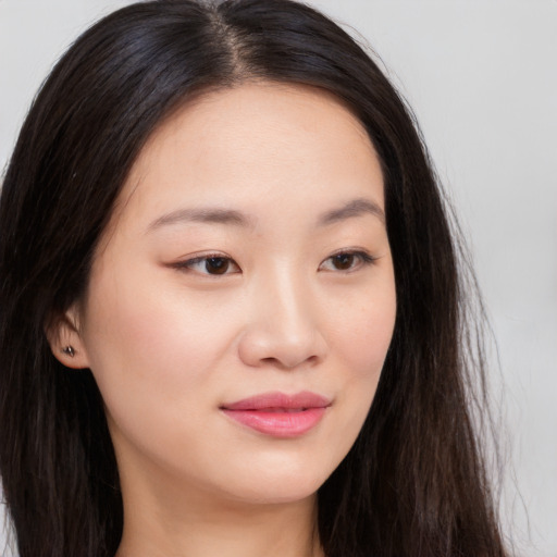 Joyful asian young-adult female with long  brown hair and brown eyes