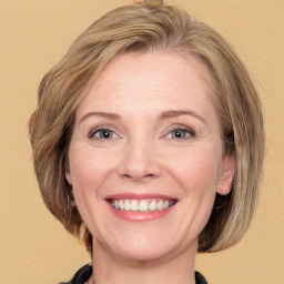 Joyful white adult female with medium  brown hair and grey eyes