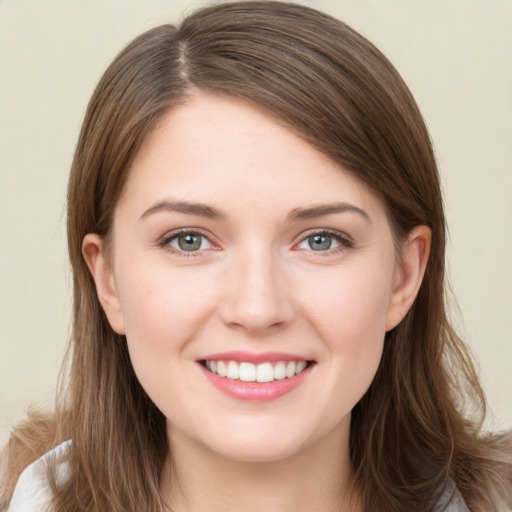 Joyful white young-adult female with long  brown hair and grey eyes