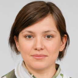 Joyful white young-adult female with medium  brown hair and grey eyes