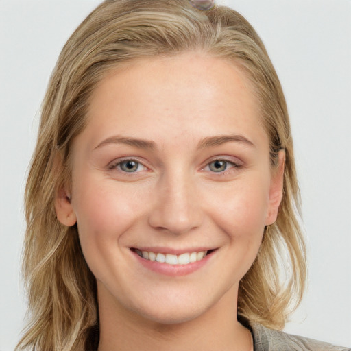 Joyful white young-adult female with long  brown hair and blue eyes