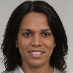 Joyful black adult female with medium  brown hair and brown eyes