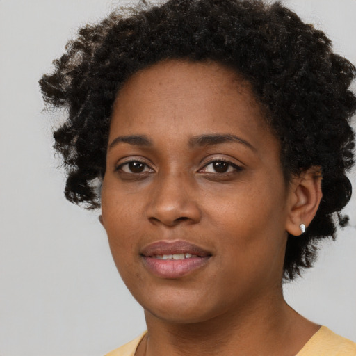 Joyful black young-adult female with short  brown hair and brown eyes