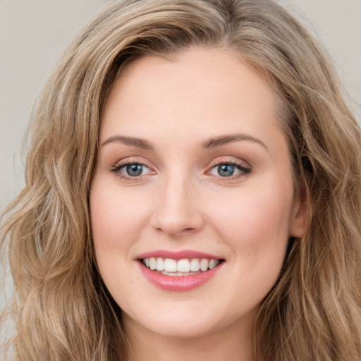 Joyful white young-adult female with long  brown hair and blue eyes