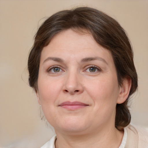 Joyful white adult female with medium  brown hair and grey eyes