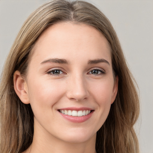 Joyful white young-adult female with long  brown hair and grey eyes