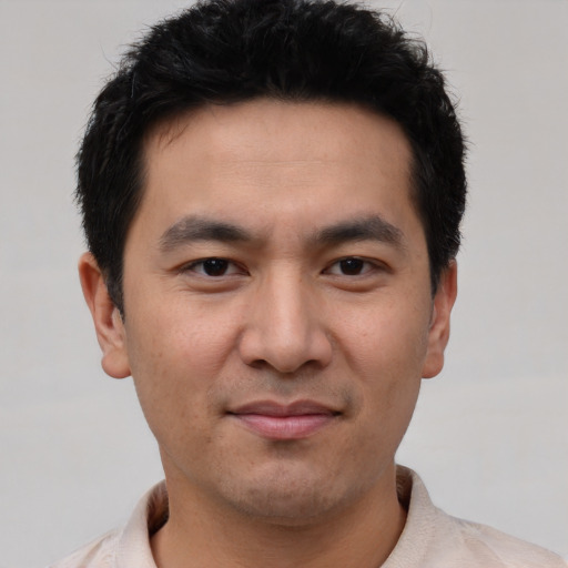 Joyful asian young-adult male with short  black hair and brown eyes