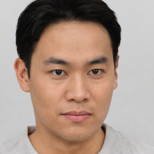 Joyful asian young-adult male with short  brown hair and brown eyes