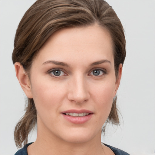 Joyful white young-adult female with medium  brown hair and grey eyes