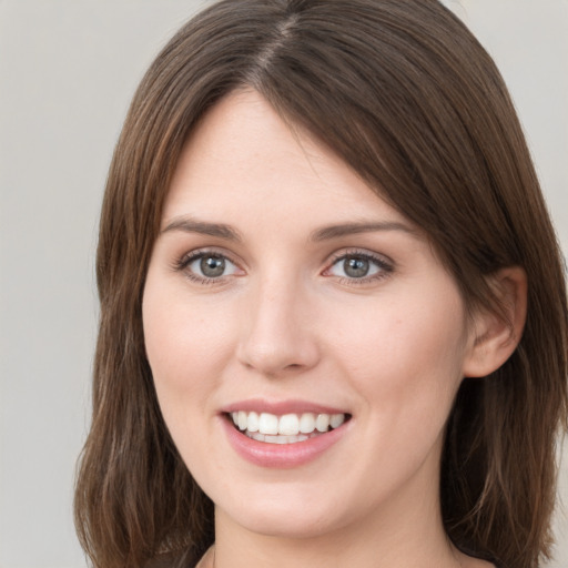 Joyful white young-adult female with medium  brown hair and grey eyes