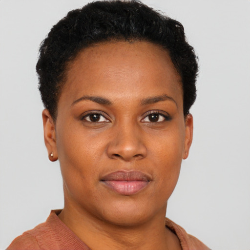 Joyful black young-adult female with short  black hair and brown eyes